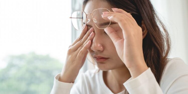 Junge Frau reibt sich die trockenen Augen